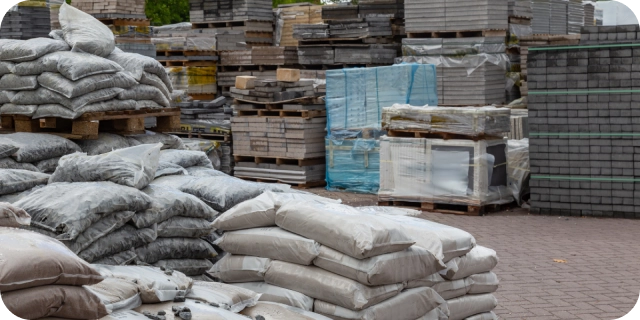 Materiales de construcción, entre ellos cemento y bloques, todo dentro de una casa de materiales